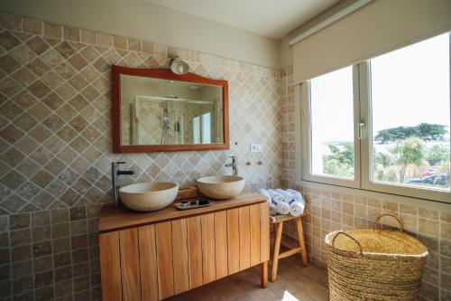 巴尔巴特尔Hôtel Le Noirmoutier的木制橱柜上带两个水槽的浴室