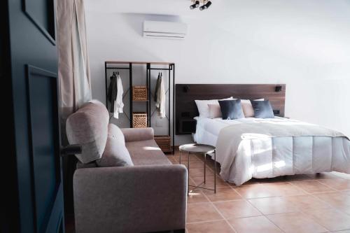 巴埃萨Nido Baeza Suites的一间卧室配有一张床、一把椅子和一张沙发