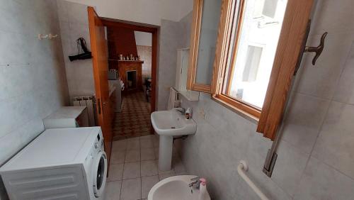 普尔萨诺JONIA Appartamento vacanze vicino al mare con giardino的一间带水槽和卫生间的浴室以及窗户。
