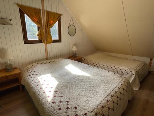 巴斯洛内特Chalet confort • Barcelonnette的一间卧室设有两张床和窗户。