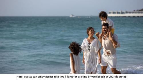 迪拜Jumeirah Mina A'Salam的三人站在海滩上