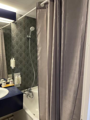 穆捷Cit'Hôtel le Welcome的浴室配有淋浴帘和盥洗盆。