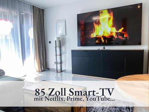 绍纳赫Relax-Apartment 164 mit Indoor-Pool, Sauna, Küche und Netflix的一间带电视和壁炉的客厅