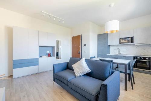 普拉托Appartamento Michelangelo的一间带蓝色沙发的客厅和一间厨房