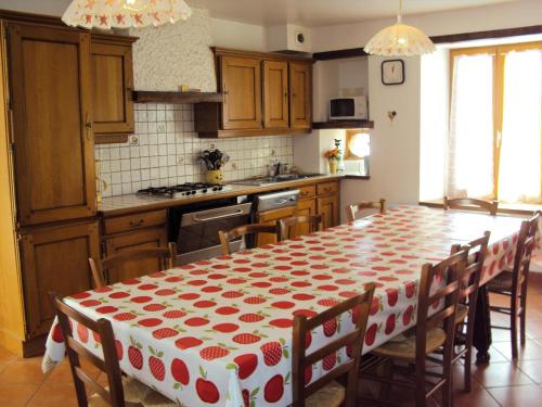 Chez laure的厨房配有一张带红白桌布的桌子