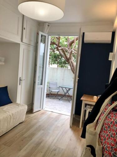 戛纳Studio bord de mer, Croisette, Cannes的一间设有一张床和一个带桌子的推拉门的房间