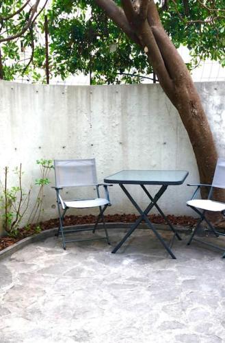 戛纳Studio bord de mer, Croisette, Cannes的桌子和两把椅子坐在树边