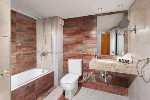 斯卡拉埃雷索Aeolian Village Beach Resort的浴室配有卫生间、浴缸和水槽。