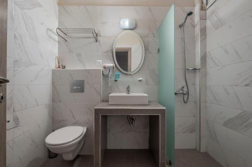 新马尔马拉斯Sunshine Apartments的一间带水槽、卫生间和镜子的浴室