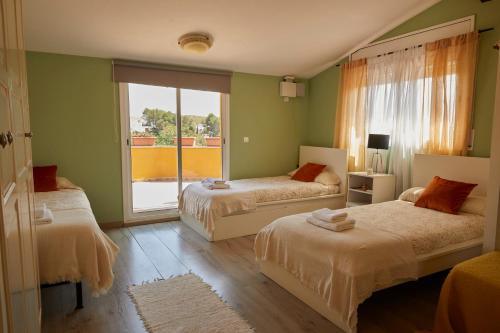 奥利维拉Amazing Vila close to Sitges, jacuzzi, swimming pool & exellent views的一间卧室设有两张床和大窗户