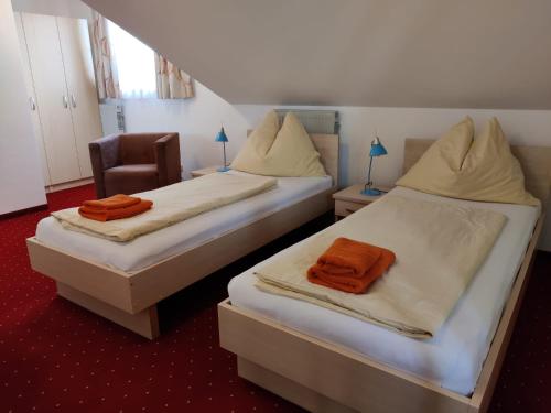 阿特尔高地区圣格奥尔根Pension Holzapfel的两张带橙色毛巾的床。