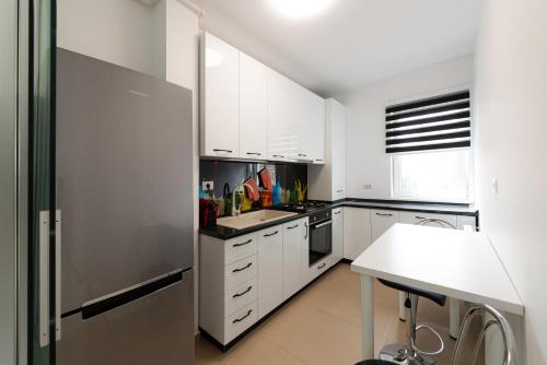 布加勒斯特Eva的厨房配有白色橱柜和不锈钢冰箱