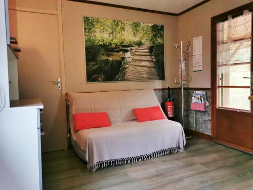 Saint-Jean-aux-BoisLe cailloutis的一间卧室配有一张带两个红色枕头的床