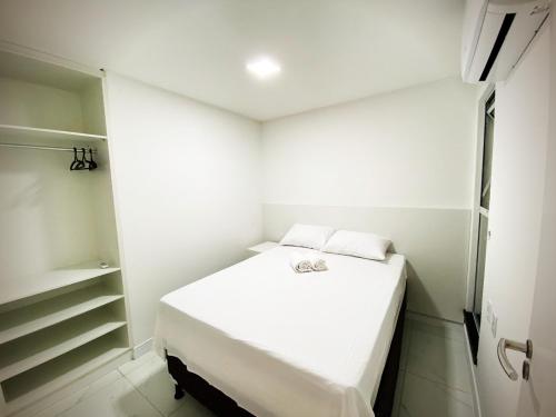 福塔莱萨Aquarius Residence的一间白色的小房间,配有一张床和一个衣柜