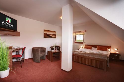 Alfrédov阿尔弗莱多福高尔夫康体度假酒店的酒店客房配有一张床、一张桌子和一把椅子。