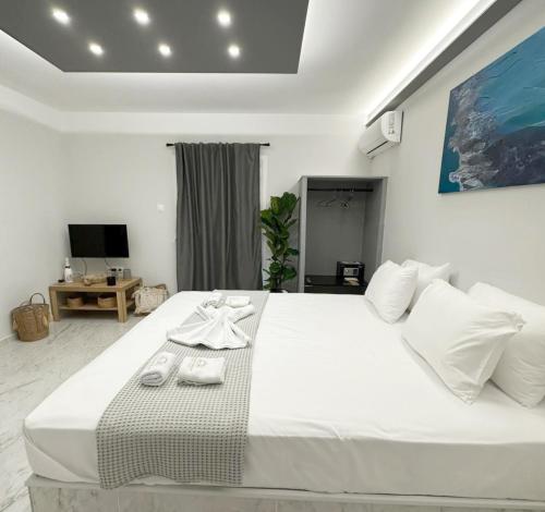 MandrakiaMora Houses的卧室配有带毛巾的大型白色床
