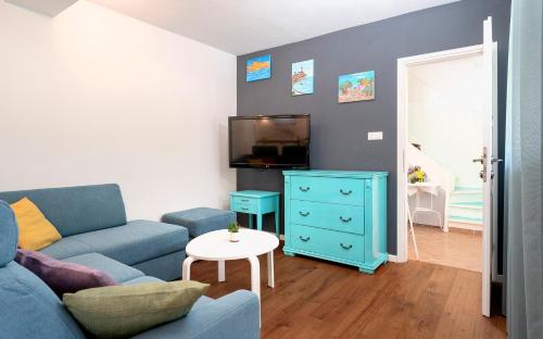 BrusjeStiniva Bay - Hvar Villa的客厅配有蓝色的沙发和电视