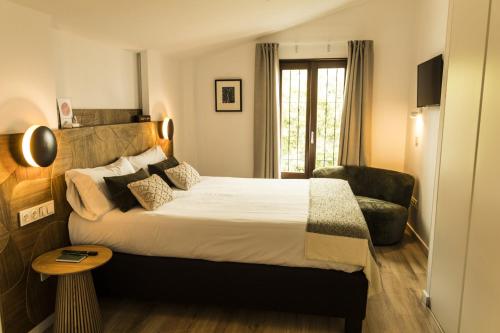 阿尔啼Hostal del vino LA COSTERA的配有一张床和一把椅子的酒店客房