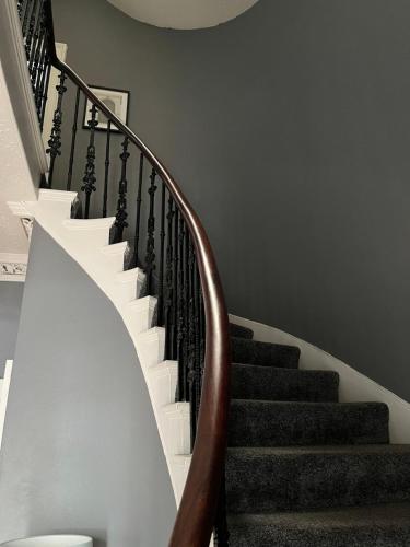 邓弗里斯Glenaldor House B&B的白色和棕色栏杆的楼梯