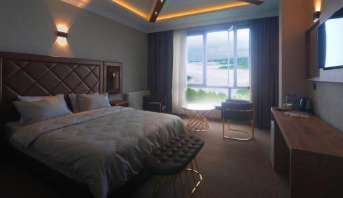 阿克恰阿巴德SIRT BUTİK HOTEL的酒店客房设有一张床和一个大窗户