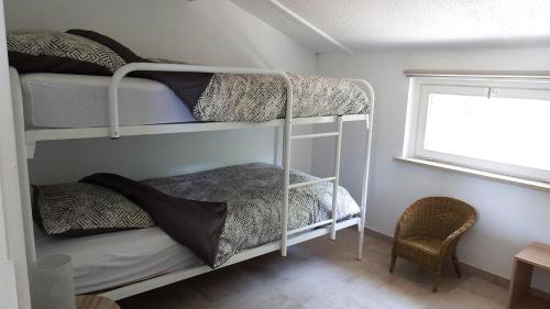 科克赛德a l'aise aan zee的一间卧室设有两张双层床和一扇窗户。