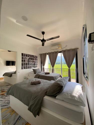 珍南海滩LamanLeman Langkawi的一间卧室配有两张床和吊扇