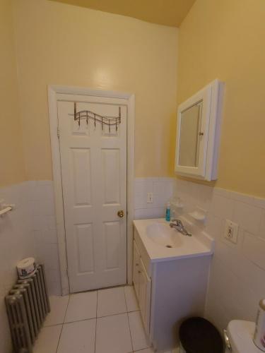 布鲁克林Crsytal Chateau Room Rental的浴室设有白色门和水槽