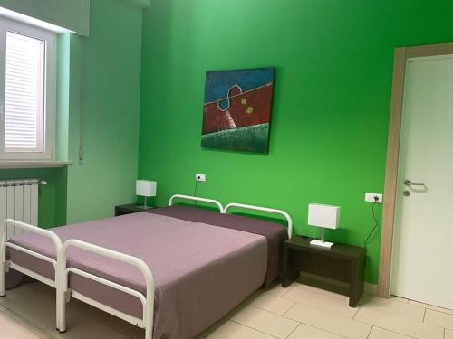 蒂勒尼亚Eliopoli Beach Hostel & Restaurant的绿色卧室,配有床和绿色的墙壁