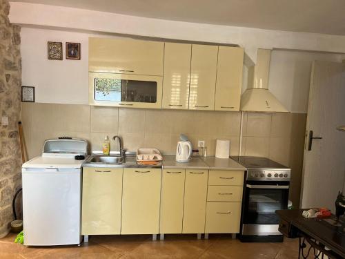 帕里斯特Apartman Dado的小厨房配有白色橱柜和水槽