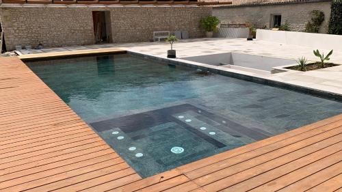 SoubiseGite de St Hilaire的一个带木制甲板和游泳池的大型游泳池