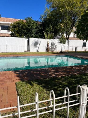 哈博罗内Comfy Zone Apartment的一个带围栏的院子内的游泳池