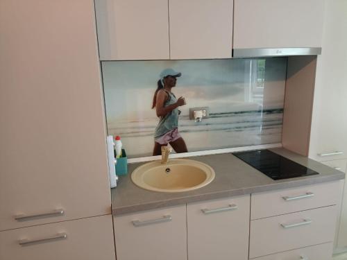 那沃达利Studio Alezzi Beach Resort Ely的站在带水槽的厨房中的女人