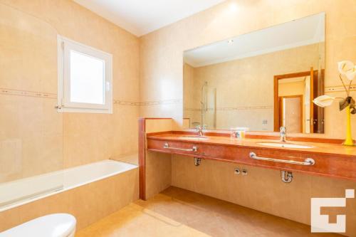 卡尔佩Villa Casanova - Grupo Turis的一间带水槽、浴缸和镜子的浴室