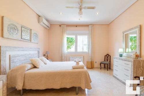 卡尔佩Villa Casanova - Grupo Turis的一间卧室设有一张大床和两个窗户。