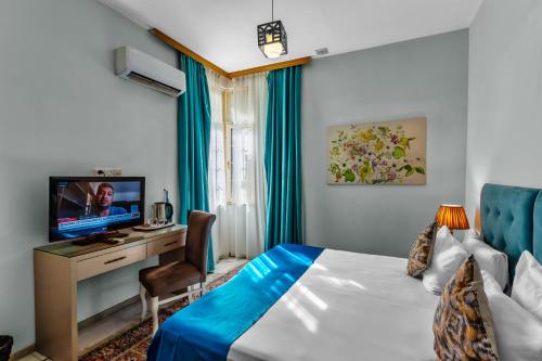 巴库Lacasa Nizami Street的酒店客房设有一张床、一张书桌和一台电视机。