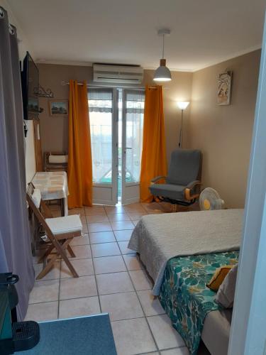 艾格-莫尔特AIGUES MORTES Studio de Vacances en Camargue的一间卧室配有一张床、一张桌子和一把椅子