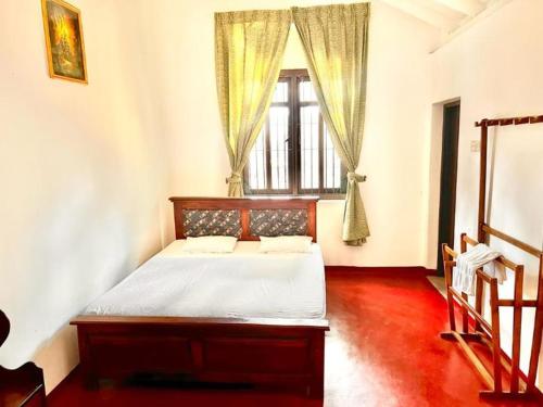 康提Sadamadala Guest House Kandy的一间卧室设有一张床和一个窗口