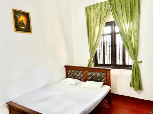康提Sadamadala Guest House Kandy的窗户客房内的一张床位