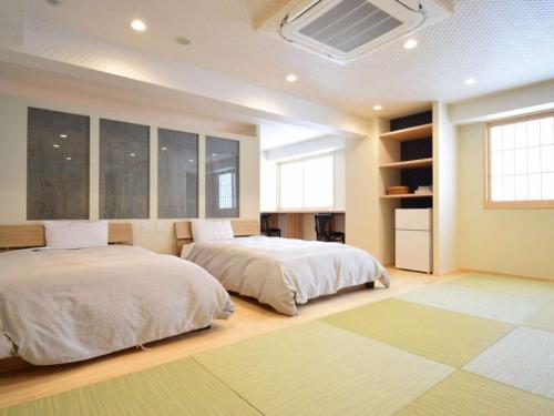 琴平町こんぴら温泉湯元八千代的一间卧室设有两张床和窗户。