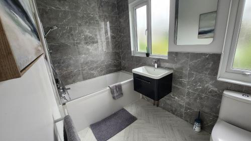 布莱顿霍夫Contemporary beach apartment的一间带水槽、浴缸和卫生间的浴室