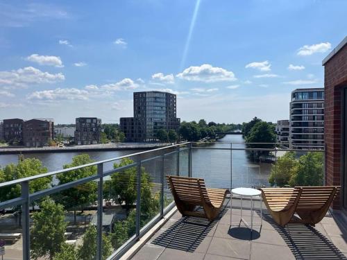奥尔登堡Penthouse-Wohnung mit Flussblick的两把椅子坐在俯瞰着河流的阳台