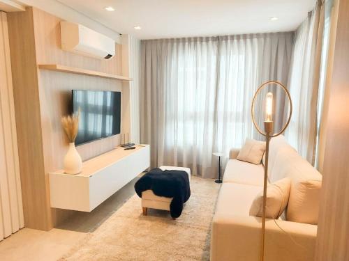 本图贡萨尔维斯VILLA DI TONDO HOUSE - APARTAMENTO ESPETACULAR的客厅配有电视和白色沙发。