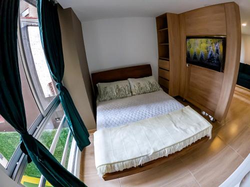 波哥大Cómodo apartamento tipo Loft en centro de Bogotá 5的一间卧室设有一张床和一个大窗户