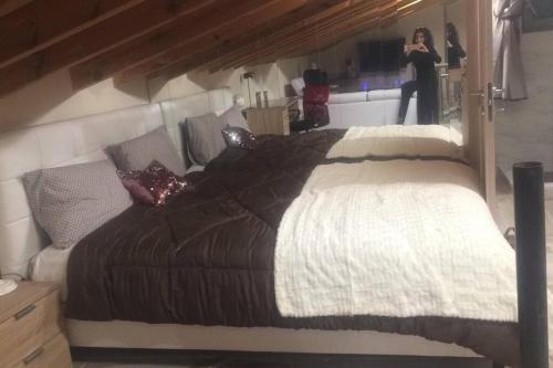米蒂利尼1 bedroom loft at Mytilene Port的一位在屋子里拍一张床的女人