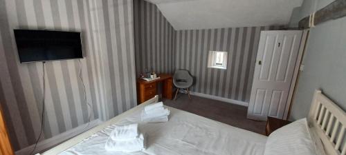 TrullWinchester Arms的酒店客房,配有床和电视