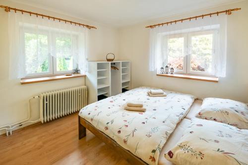 Chalupa Poustka的一间卧室设有两张床和两个窗户。
