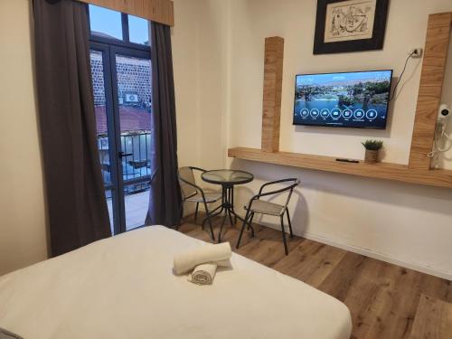 提比里亚מלון טיבריא的客房设有床、桌子和窗户。