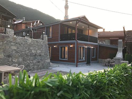 乌宗Garden House Uzungöl的一座带石墙的大型木制房屋