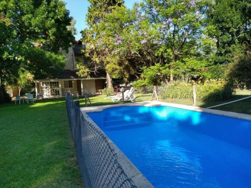 贝拉维斯塔Casa amplia - Pileta y parque的庭院旁带围栏的蓝色游泳池