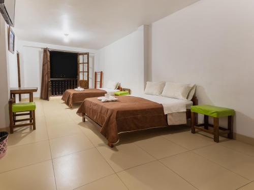 查查波亚斯Hostal La Morada的一间卧室设有两张床、一张桌子和一个窗口